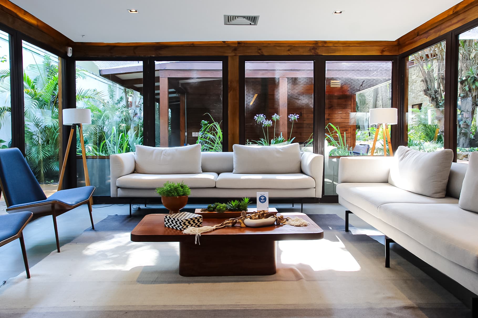 Lounge da clínica com sofás de design e vista para o jardim interno